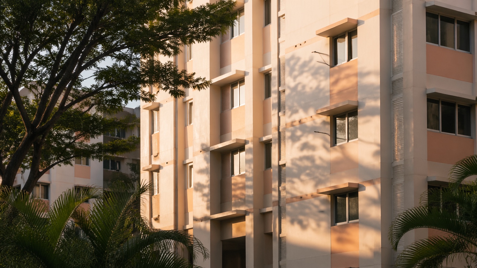 A Singapore HDB public housing block in East Singapore, freshly repainted in cream and soft peach, bathed in late-afternoon golden light